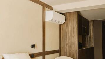 Une chambre d’hôtel moderne, équipée d’un lit, d’une chaise et d’une armoire intégrée.