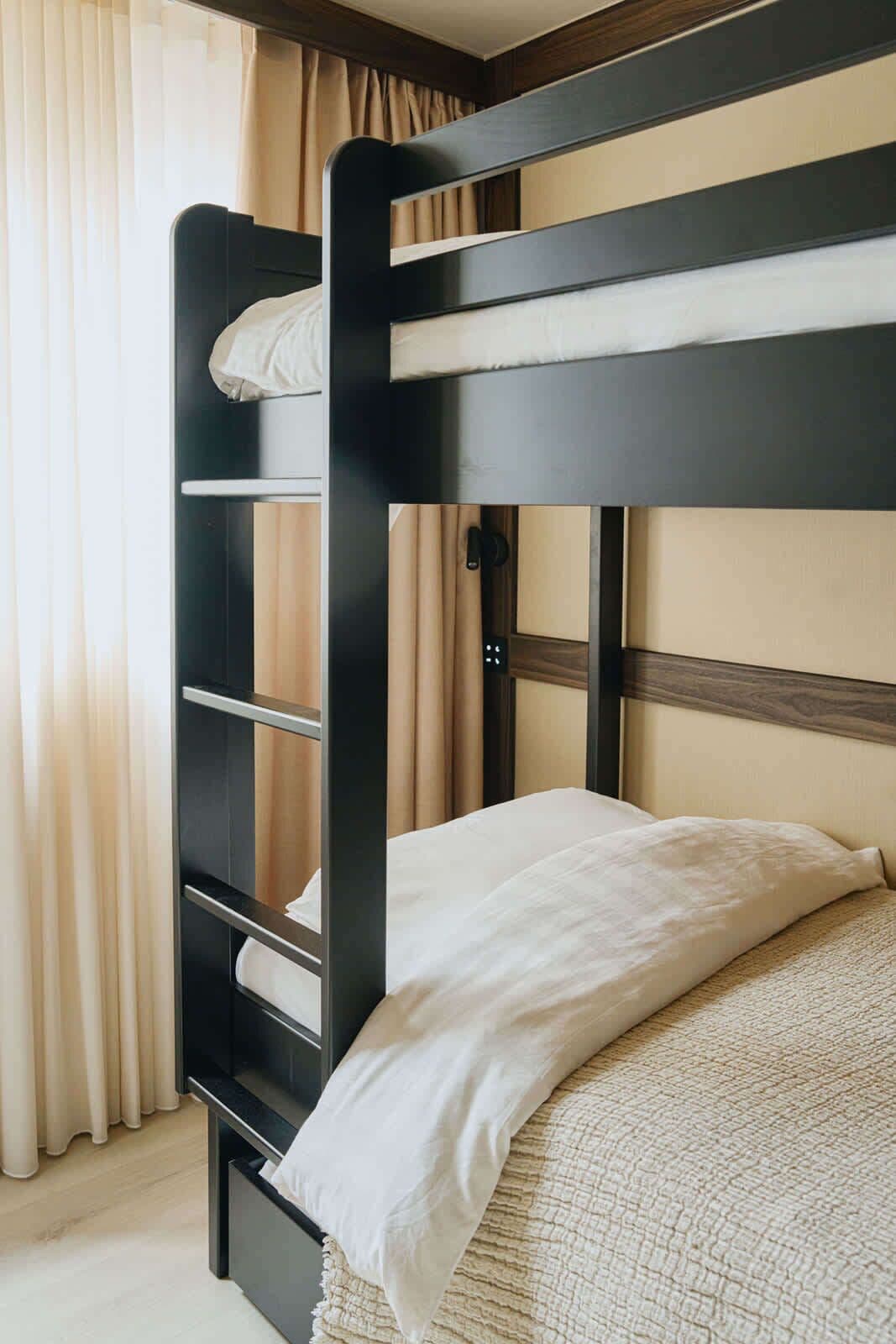 Un lit superposé avec une tête de lit en bois et un matelas blanc.