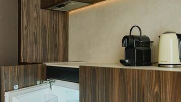 Una cocina moderna con armarios de madera, horno empotrado, hervidor y lavavajillas.