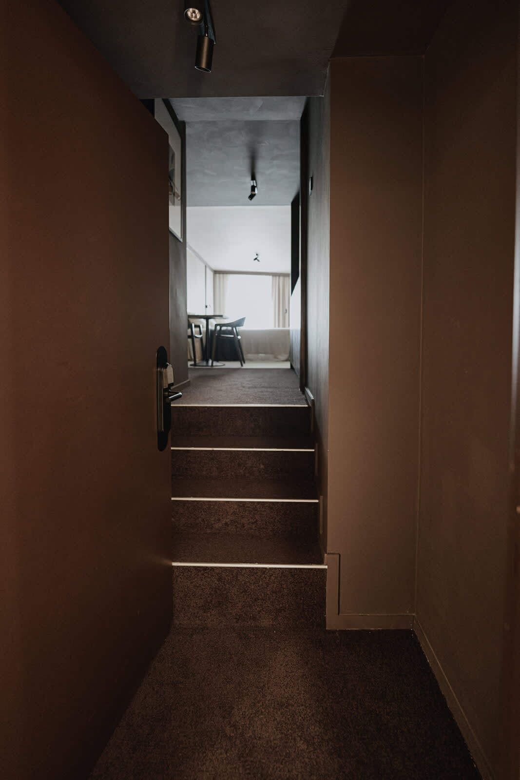 Un escalier menant à un balcon agrémenté d’une table et de chaises.