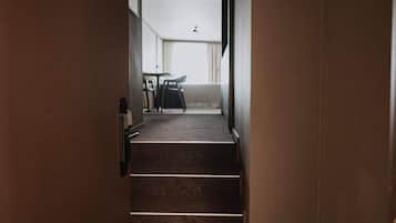 A staircase leading to a balcony with a table and chairs.