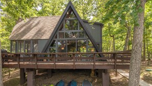 A cabin with a wooden deck and a glass enclosure.