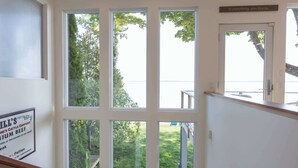 Una escalera con ventilador de techo, ventanas amplias y un letrero en la pared.