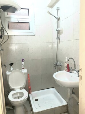 Een douche, handdoeken, zeep, toiletpapier