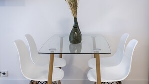 Un comedor moderno con una mesa de vidrio y sillas blancas.