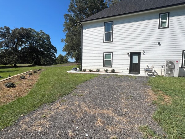 A two-story white house with a black door, a small porch with a chair, and an air conditioning unit on the right side. - The Place to Stay - 3 Bedroom and 2 Bath (Molena)