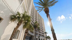 Un hôtel de grande hauteur doté de nombreux balcons et bordé de palmiers.