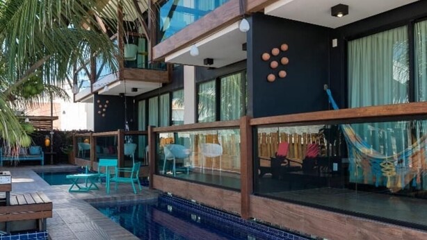 Un hôtel moderne doté d’une piscine, d’un espace extérieur aménagé et de grandes fenêtres.