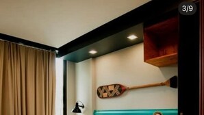 Une chambre à coucher comprenant un lit, une tête de lit, une table de chevet, une lampe et un objet décoratif fixé au mur.