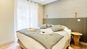 A modern bedroom with a large bed, a bedside table, and a patterned wall. - Superb Apartment Center of Paris (Paris)