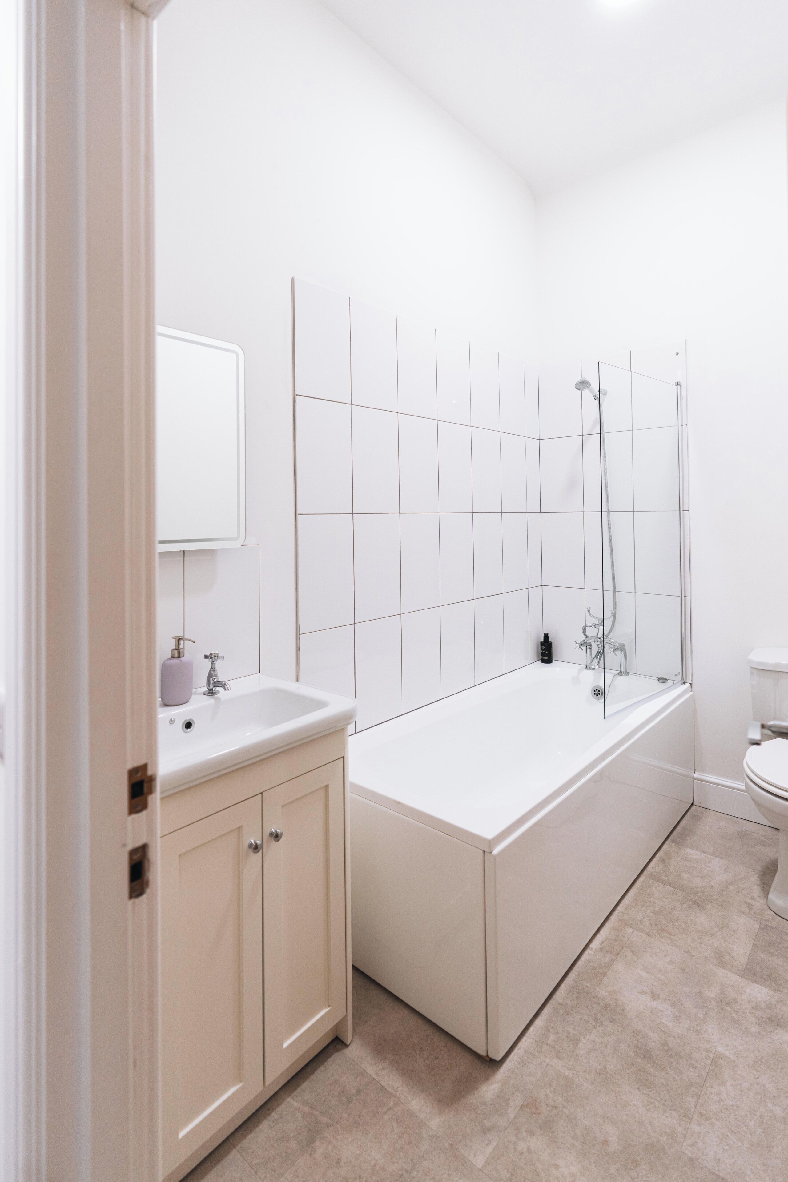 Ein Badezimmer mit einem weißen Waschbecken, einem Spiegel und einer Badewanne.
