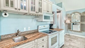 A kitchen with white cabinets, a granite countertop, a stainless steel sink, a microwave, a stove, and a dishwasher. - Adorable Upstairs 2 BR Nantucket 6AB (Destin)