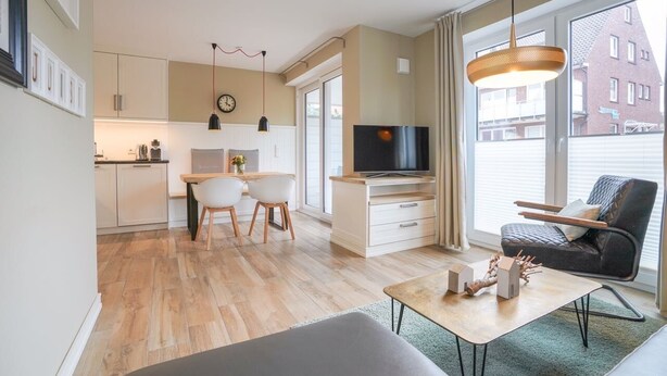 Eine moderne Wohnung mit Küche, Essbereich, Wohnzimmer und einem großen Fenster mit Blick auf die Stadt.