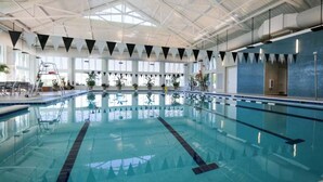 An indoor swimming pool with clear lanes, a ladder, and a lifeguard chair. - Dog‑Friendly (Only 1) Bayside Condo w/ Pool & Gym (Selbyville)