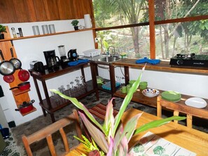 A compact kitchen with wooden cabinets, a coffee maker, and a blender. - Paradiselodge - Romantic Hideaway, next to Nauyaca (Platanillo de Baru)