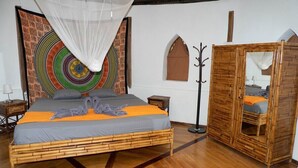 A room with a bed, a wardrobe, a tapestry, and a coat rack. - Paradiselodge - Romantic Hideaway, next to Nauyaca (Platanillo de Baru)