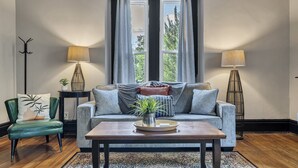 Un salon comprenant un canapé, une table basse, un fauteuil et deux lampes.