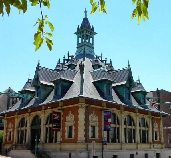 A historic building with a steeply pitched roof, multiple gables, and a central tower.