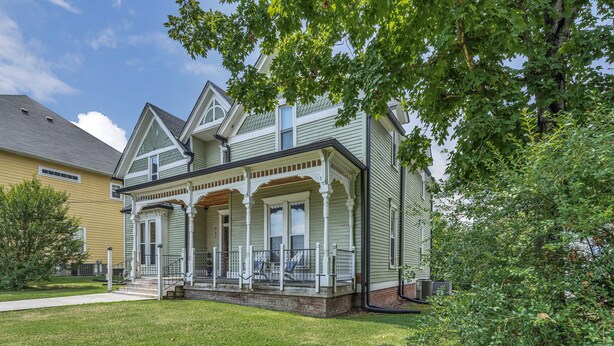 A two-story house with a front porch, a covered entryway, and a small front yard. - Unit #4 117 Marion St (Clarksville)