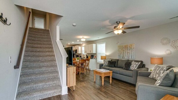 A spacious living area with a staircase, a dining area, and a kitchen.