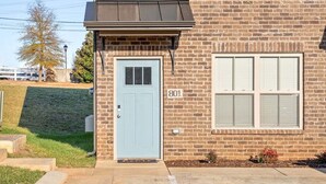 Un edificio de dos pisos con una puerta azul claro y el número 801 en la pared.