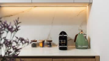 Uma bancada de cozinha com uma cafeteira, um bule e potes de temperos.