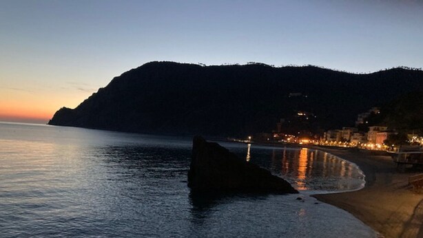 A coastal scene with a rocky shoreline, calm water, and a distant mountain. - Gianlu' Cosy Apartment with A/C (Monterosso al Mare)