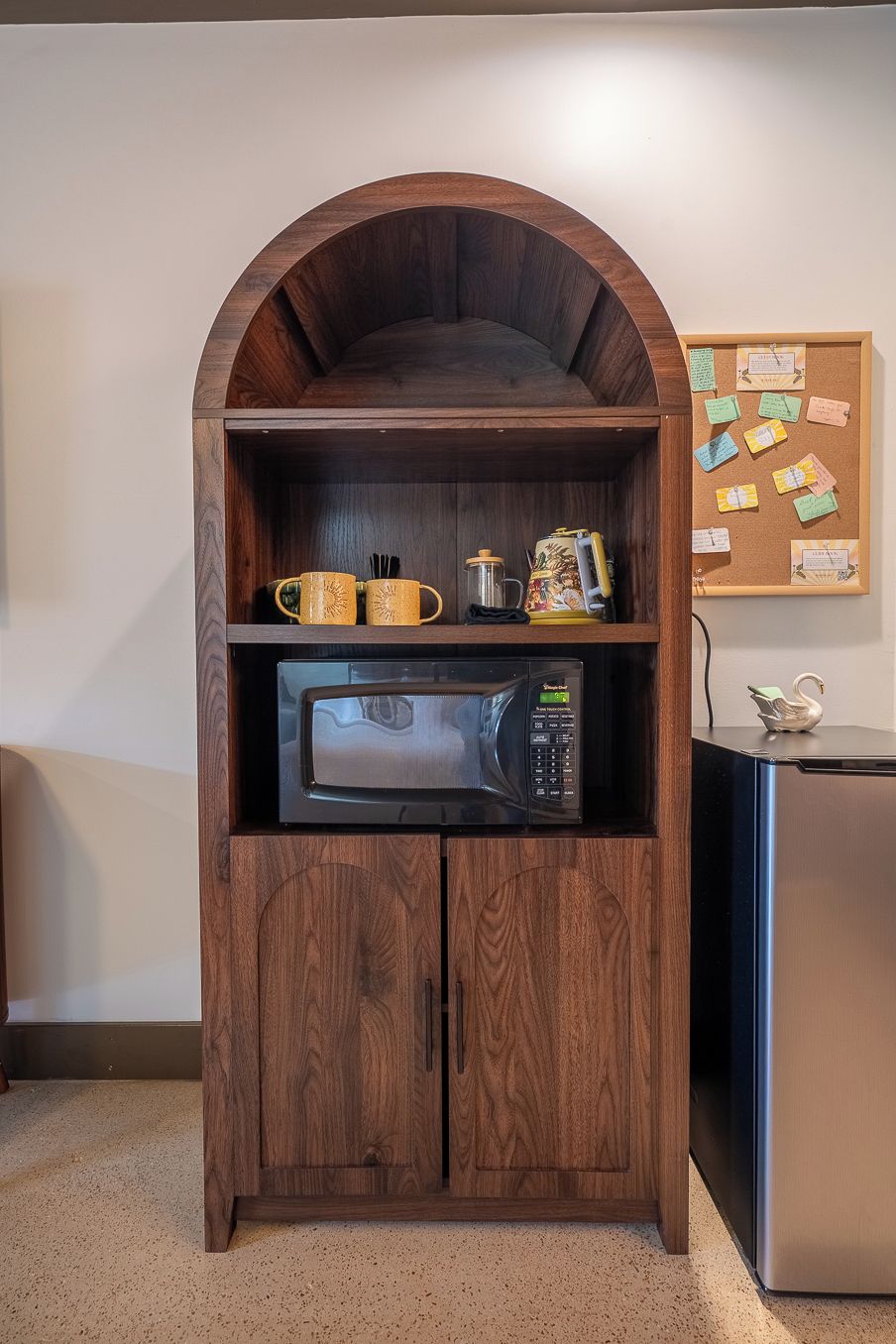 A kitchenette with a microwave, a coffee maker, and mugs.