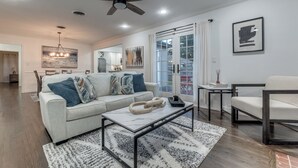 Una sala de estar moderna con sofá, mesa de centro y ventilador de techo.