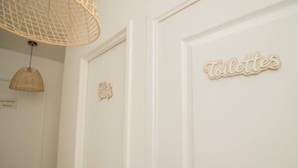 Uma porta branca com uma placa que diz 'Toilettes' e outra placa que diz 'La Chambre'.