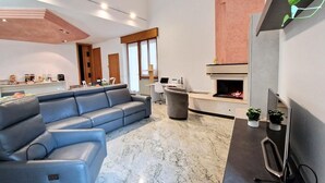 A modern living room with a sectional sofa, a fireplace, and a television.