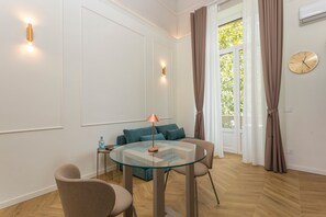 Un salon moderne avec une table en verre, un canapé et une lampe.
