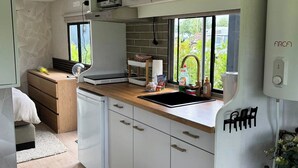 Een compacte keuken met witte kasten, een houten aanrechtblad en een ingebouwde vaatwasser.