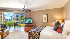 Une chambre d’hôtel avec un balcon, un lit, une télévision et un bureau avec une chaise.