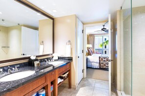 Une salle de bain d’hôtel avec deux lavabos, un grand miroir et un espace douche.