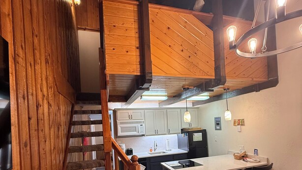 A wooden staircase leading to a kitchen with a dining area. - Walk to Giant Steps •1BR+Loft • Fireplace• Fast Wi-Fi• Sleeps 6 •Mountain Views (Brian Head)