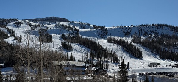 A snow-covered mountain with ski slopes, a ski lift, and a small building at the base. - Walk to Giant Steps •1BR+Loft • Fireplace• Fast Wi-Fi• Sleeps 6 •Mountain Views (Brian Head)