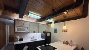 A modern kitchen with a central island, built-in appliances, and pendant lighting. - Walk to Giant Steps •1BR+Loft • Fireplace• Fast Wi-Fi• Sleeps 6 •Mountain Views (Brian Head)