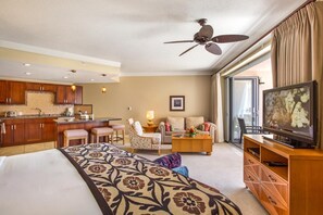Une chambre d’hôtel équipée d’un lit, d’un canapé, d’un coin repas, d’une télévision et d’un ventilateur de plafond.