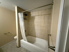 Ein Badezimmer mit Badewanne, Duschbereich und Toilette.