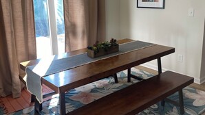 A dining area with a wooden table, bench, and chandelier.