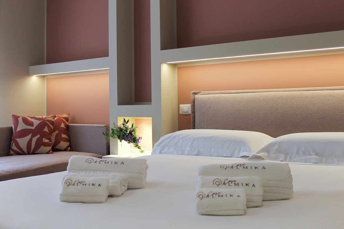 A hotel room with a bed, pillows, and towels.