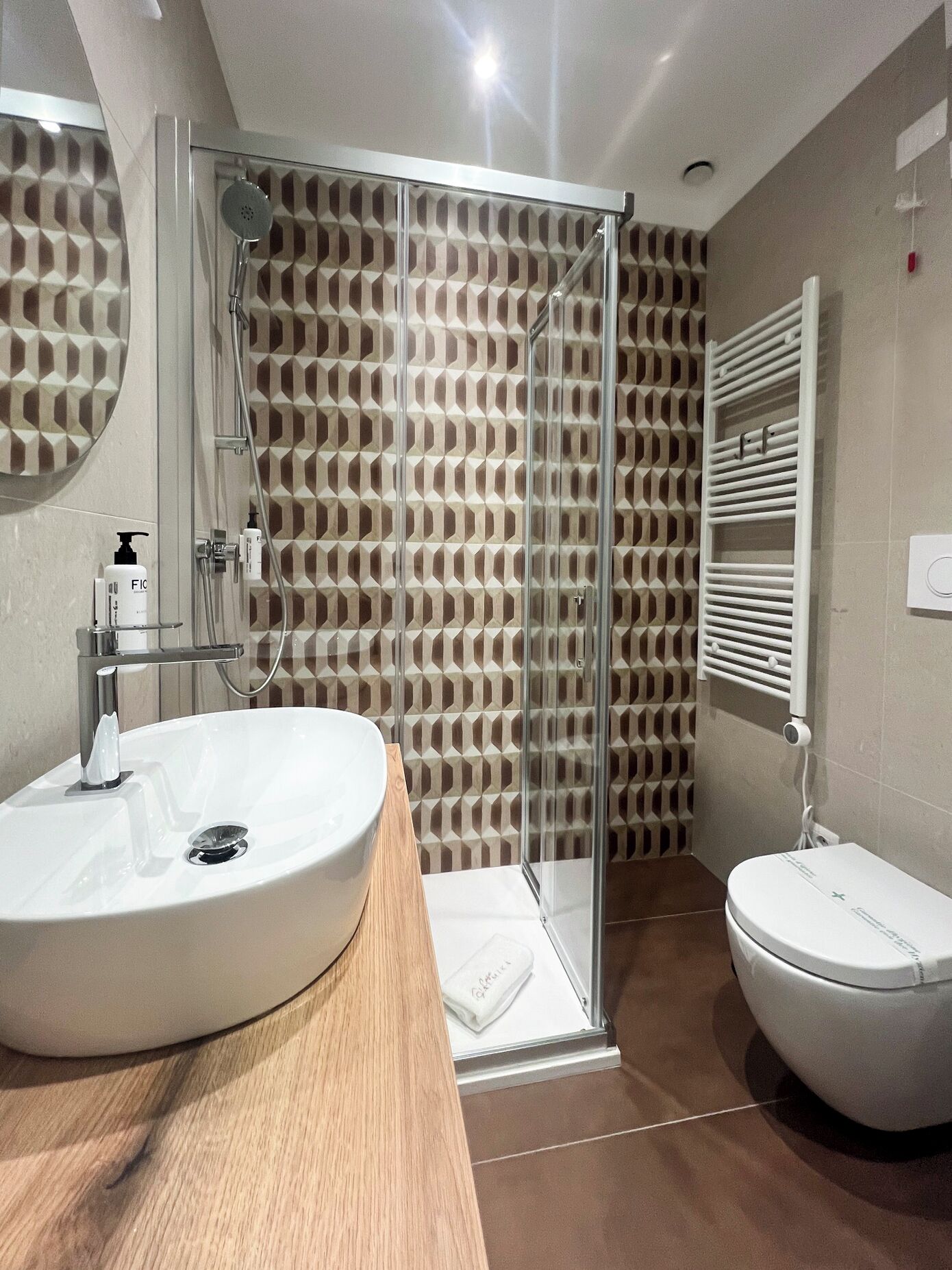 Une salle de bain moderne avec une douche à parois de verre, un lavabo blanc et des toilettes.