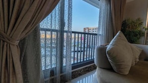 A balcony with a view of buildings and a plant.