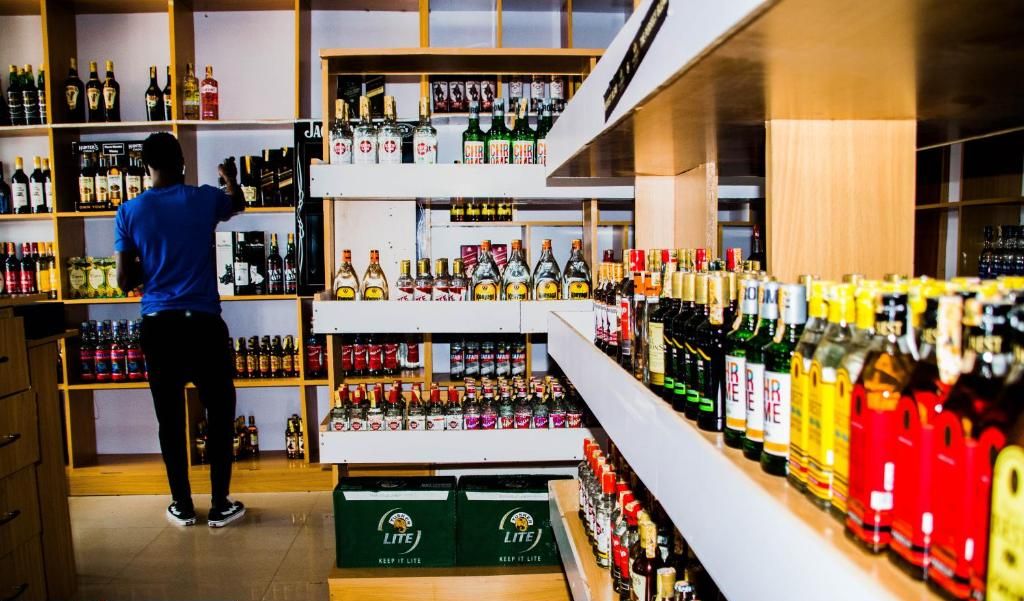Uma loja de bebidas alcoólicas com prateleiras repletas de garrafas e caixas.