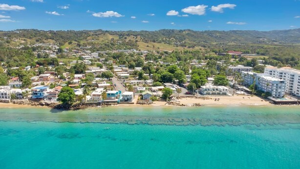 A coastal resort with beachfront villas, a sandy beach, and a backdrop of hills. - Sunset Marena/Beach Front House (Stella)