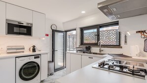 Une cuisine moderne équipée d’un lave-linge, d’un four à micro-ondes et d’une cuisinière à gaz.