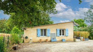 A single-story house with a small porch, a window with shutters, and a door. - Gîte 'Gite Iago' with Private Terrace, Shared Garden and Wi-Fi (Larée)
