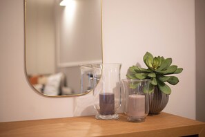 A wooden surface with two clear glass candle holders and a potted plant. - Casa Almika Sparano (Bari)