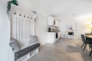 A modern kitchen with white cabinets, a built-in oven, and a coffee machine. - Accessible Apartment 'Landräume' with Wi-Fi (Lunden)